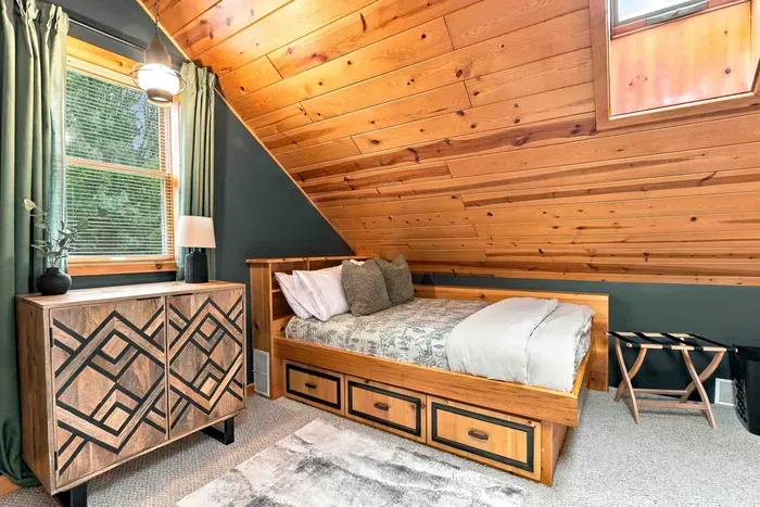 Enjoy a peaceful night's rest in this top-floor retreat offering twin beds with built-in drawers and a decorative dresser.