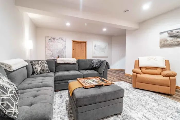 A stylish living room featuring a comfortable gray couch set against crisp white walls, creating a clean and modern space to relax.
