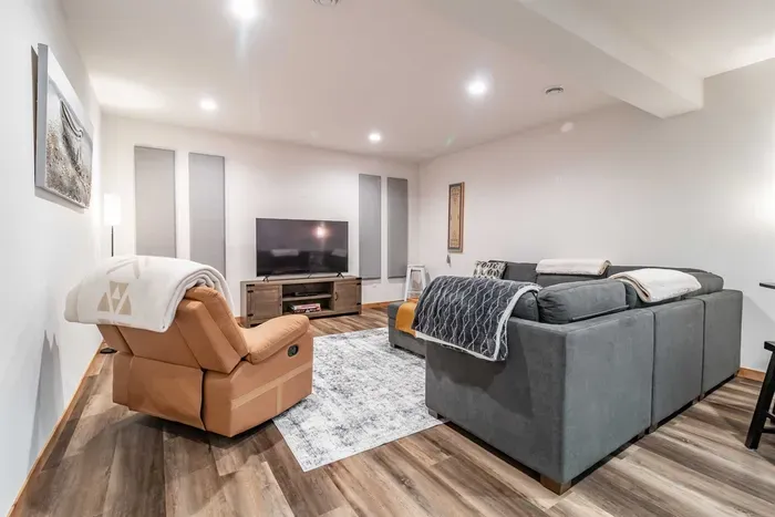 A stylish living room featuring a comfortable gray couch set against crisp white walls, creating a clean and modern space to relax.