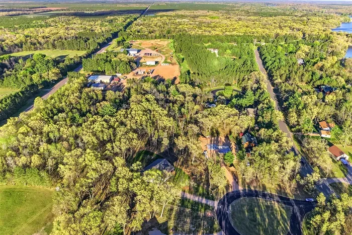 Scenic property overview highlighting mature trees, spacious neighboring acreage, and a quiet natural backdrop.