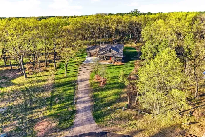 Private wooded setting with a long driveway, spacious lawn, and a peaceful home tucked among mature trees.