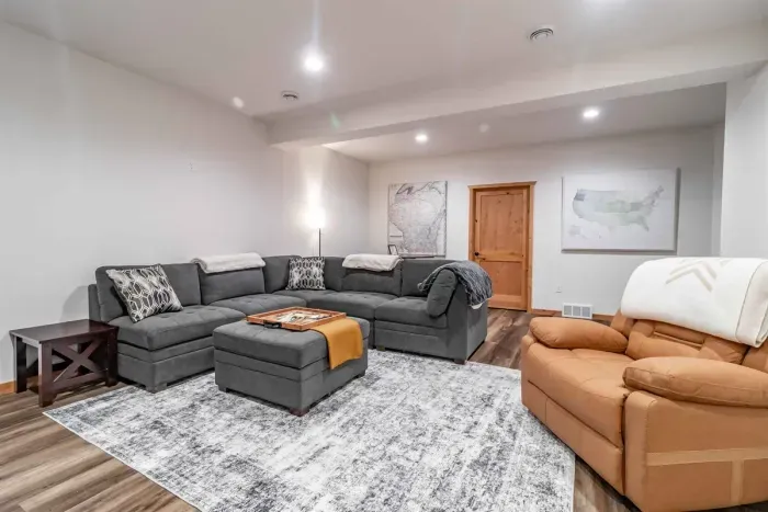 A stylish living room featuring a comfortable gray couch set against crisp white walls, creating a clean and modern space to relax.