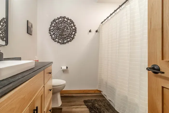 A clean, functional bathroom featuring a vanity mirror with a cabinet below, offering both style and convenient storage.