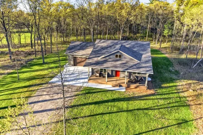 Peaceful country-style property with a welcoming front approach, attached garage, and natural privacy all around.