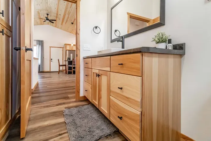 A clean, functional bathroom featuring a vanity mirror with a cabinet below, offering both style and convenient storage.