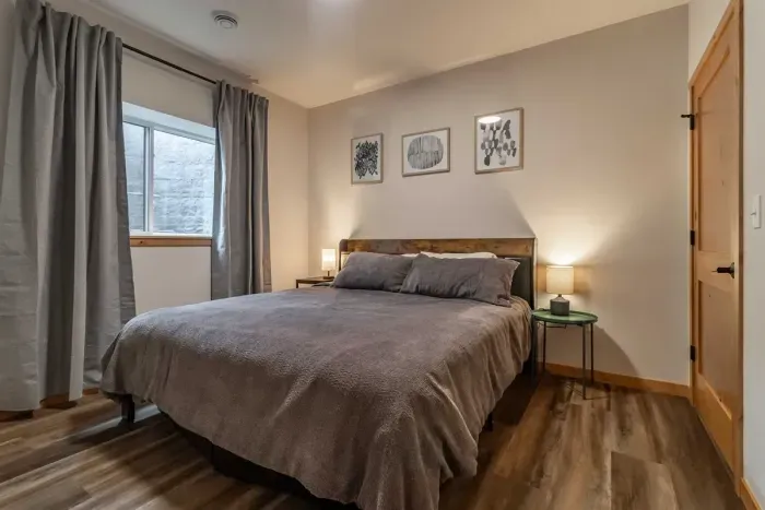 A calm, inviting bedroom dressed in soft gray sheets, creating a clean and relaxing space for restful sleep.