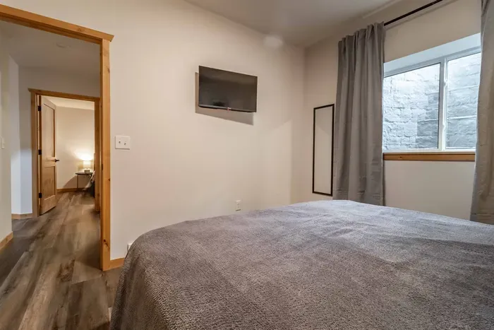 A calm, inviting bedroom dressed in soft gray sheets, creating a clean and relaxing space for restful sleep.