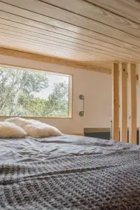 Loft daybed with large window looking into the foliage.