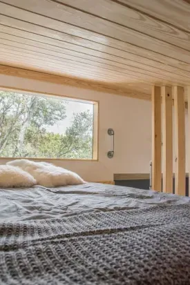 Loft daybed with large window looking into the foliage.