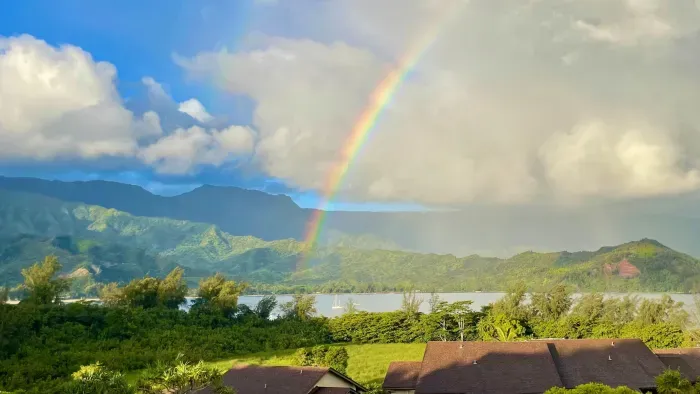Tropical bay and mountain panorama with sailboats and a rainbow view.