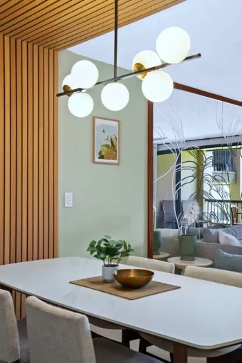 A refined dining space featuring a sleek slate wall and modern lighting