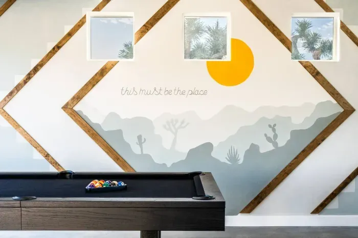 This must be the place. A vibrant mural and sleek pool table set the tone for playful nights in your Joshua Tree vacation home.