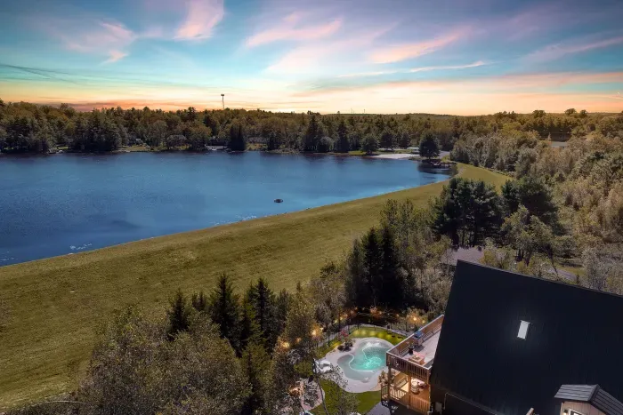 Secluded lakeside cabin with hot tub, deck, and sunset views