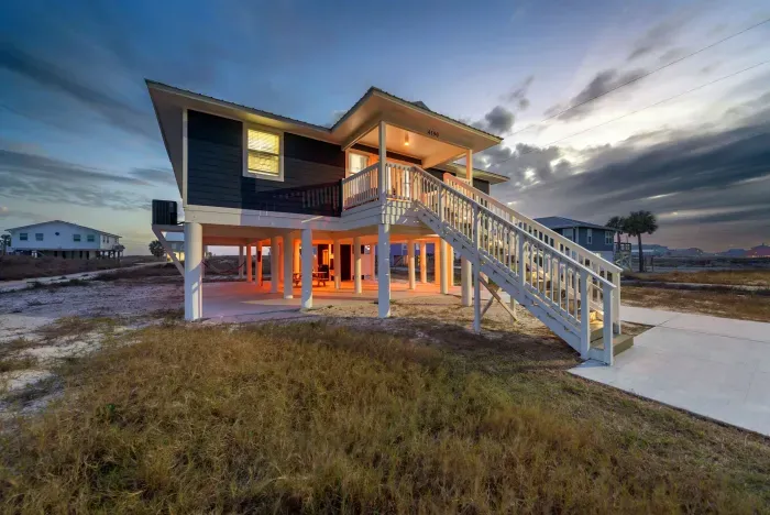 Blissful Shores after sunset, your Fort Morgan hideaway glowing under the evening sky. A modern coastal retreat where family, friends, and moments come together.