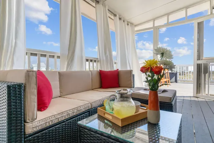 Screened-In Porch: A breezy retreat with cushioned seating, ideal for enjoying a drink, reading, or simply listening to the waves.