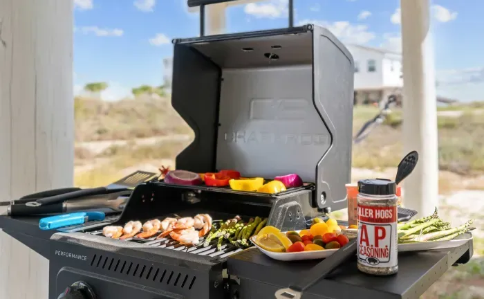 Enjoy the convenience of a gas grill set on a concrete slab under the house, ideal for family dinners or casual gatherings.