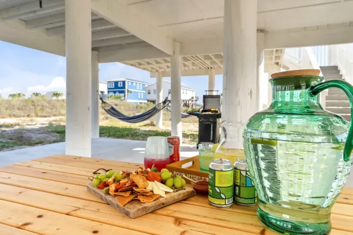 Enjoy outdoor dining at the picnic table set on the concrete slab under the house. A shaded spot for coastal meals together.