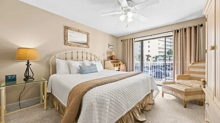 Primary bedroom with king bed and balcony access