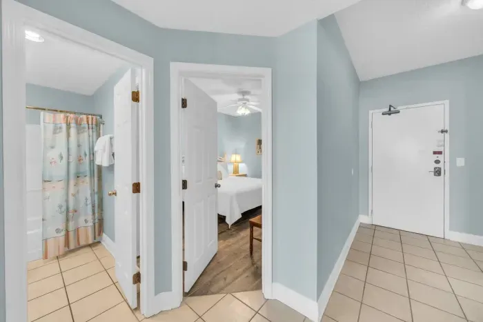 Entry way to unit and view down hall looking into guest bedroom