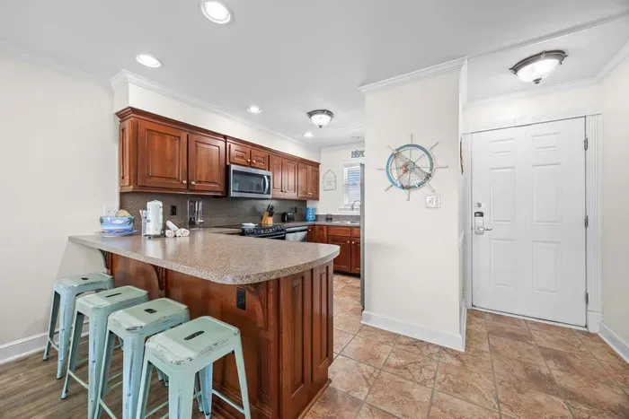 Condo entrance adjacent kitchen and breakfast bar