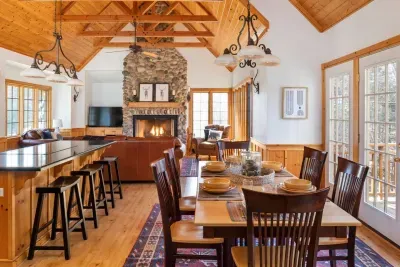 Dining Room: Gather around the rustic table and enjoy views next to a charming stone fireplace!