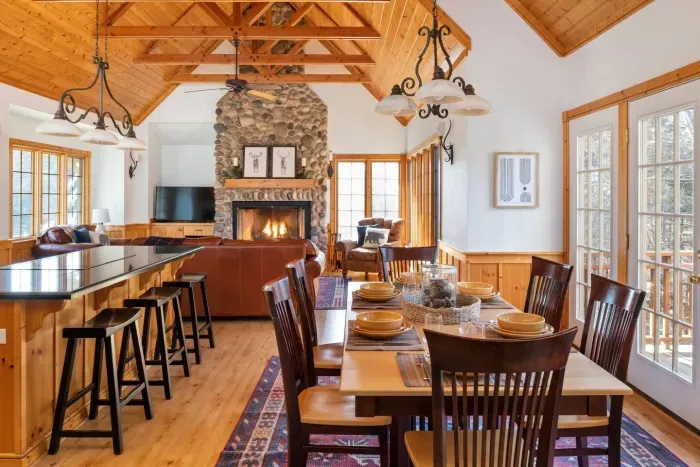 Dining Room: Gather around the rustic table and enjoy views next to a charming stone fireplace!