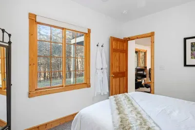 Bedroom Retreat: Sunlit room with natural views, plush bedding, and luxury robes await!