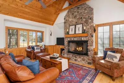 Living Room: Experience warmth by the stone fireplace, framed by rustic decor and natural light!