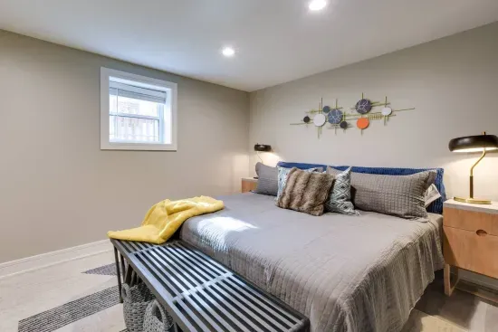 Serene Bedroom Retreat: Relax on a plush bed surrounded by modern decor and soft lighting!