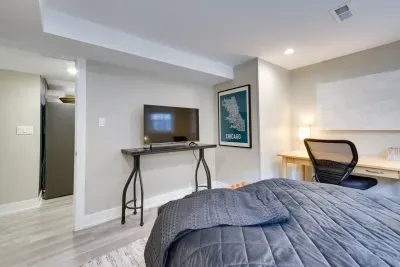 Charming Bedroom Retreat: Stylish room with a desk, TV, and vibrant Chicago art for inspiration!