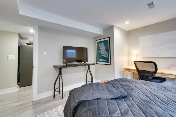 Charming Bedroom Retreat: Stylish room with a desk, TV, and vibrant Chicago art for inspiration!