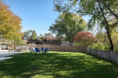 Outdoor Escape: Relax in vibrant seating amidst lush greenery and perfect for evening bonfires! Extra large and fully fenced for pups & kids to play!