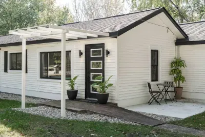 Charming Entryway: Relax on the patio with dappled sunlight amidst lush greenery!