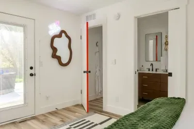 Chic Retreat: Bright room with stylish decor, modern amenities, and direct access to nature and hot tub.