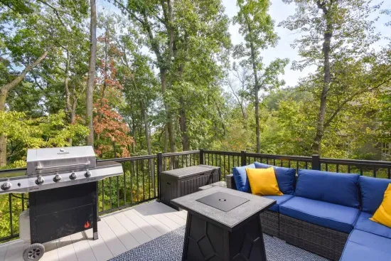 Outdoor Lounge: Sizzle on the grill and unwind with nature views from this stunning balcony in the woods!
