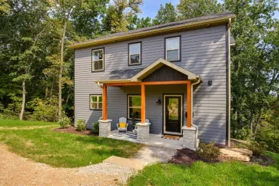 Exterior Retreat: Charming gray facade with vibrant orange accents, nestled among lush greenery!