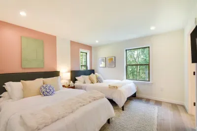 Inviting Double-Queen Bedroom: Enjoy restful nights with stylish decor and serene forest views!