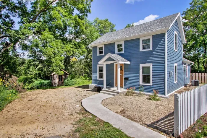 Exterior Charm: Bright blue facade welcomes you to a serene getaway surrounded by nature.