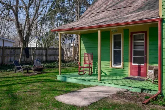 Charming porch: Sip lemonade on the vibrant rocking chair in this inviting outdoor haven!