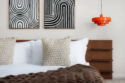 Chic Bedroom Retreat: Stylish art, plush pillows, and vibrant lighting await your perfect getaway!