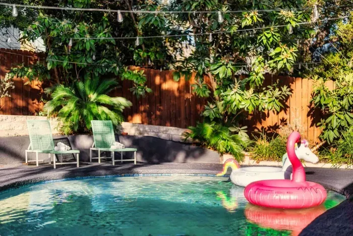 Outdoor Oasis: Dive into fun with a sparkling pool, vibrant floats, and lush greenery!