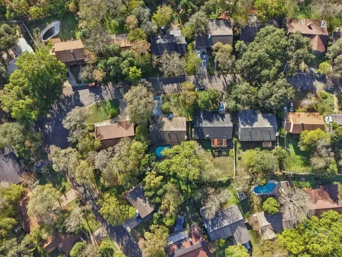 Aerial View: Discover vibrant neighborhood charm with lush greenery and inviting pools!