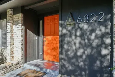 Charming Mid-Century Entrance: Bright orange door welcomes you to your Austin adventure! Explore and unwind!