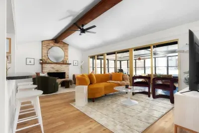 Living Room: Bright and airy space with vibrant seating and a charming fireplace for gatherings!