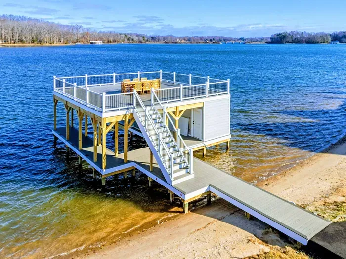 A beautiful two-level dock extends over the lake, complete with a dining area and stunning water views, ideal for relaxation and entertaining.