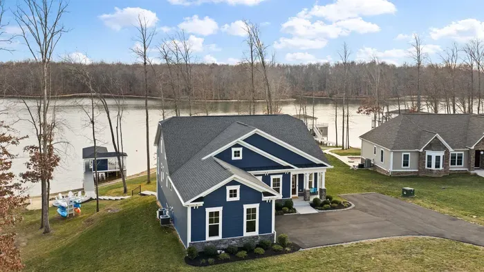 Exterior - An aerial from the right side shows the full property from the driveway to the boathouse, cove beyond.