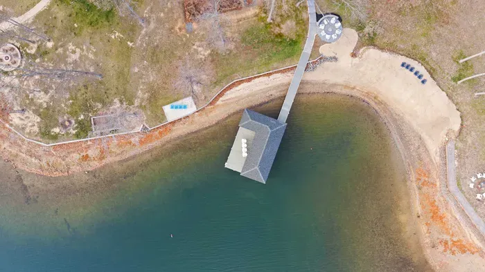 Exterior - An aerial top-down view shows the boathouse, dock, fire pit circle, and kayaks on the shore.