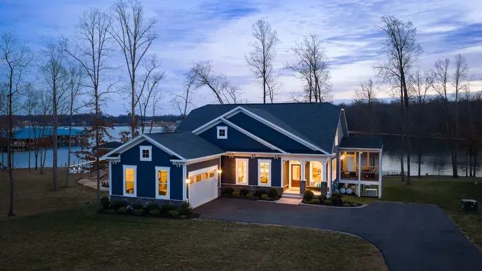 Exterior - A blue-hour aerial from the front captures Summer's Landing: craftsman blue, covered porch, and the lake behind.
