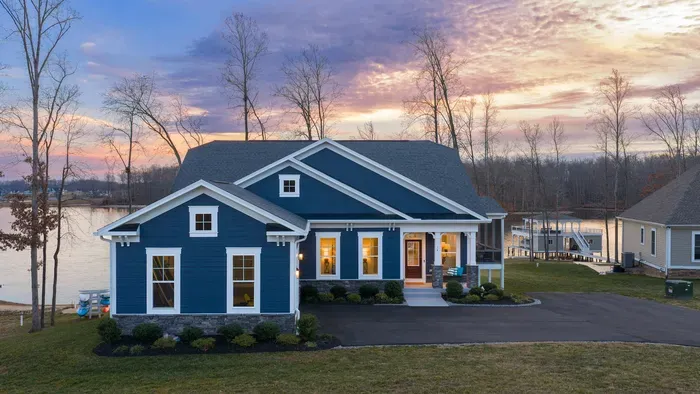 Exterior - A sunset aerial from the front shows the craftsman exterior glowing under a purple and pink sky.