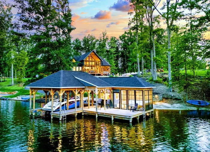 Waterfront at Twilight - Ober The Lake glows warmly from the hillside, with the covered dock and boathouse lit up on the water at sunset.